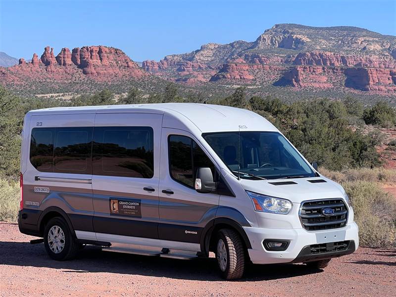 Grand Canyon Journeys 2020 Ford Transit passenger van parked in front of Sedona's red rocks