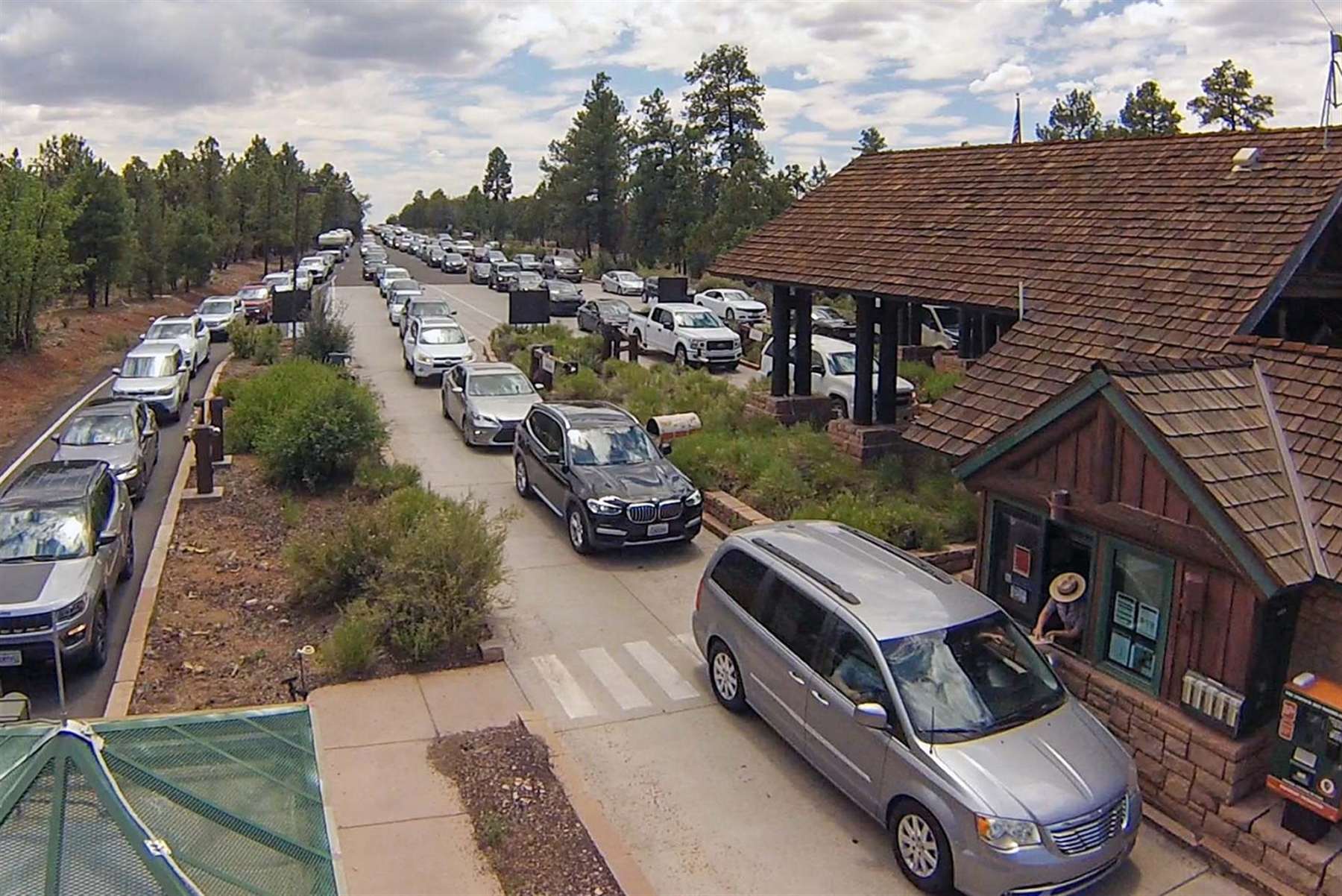 Cars lined up at the Grand Canyon National Park entrance station where rangers collect entrance fees