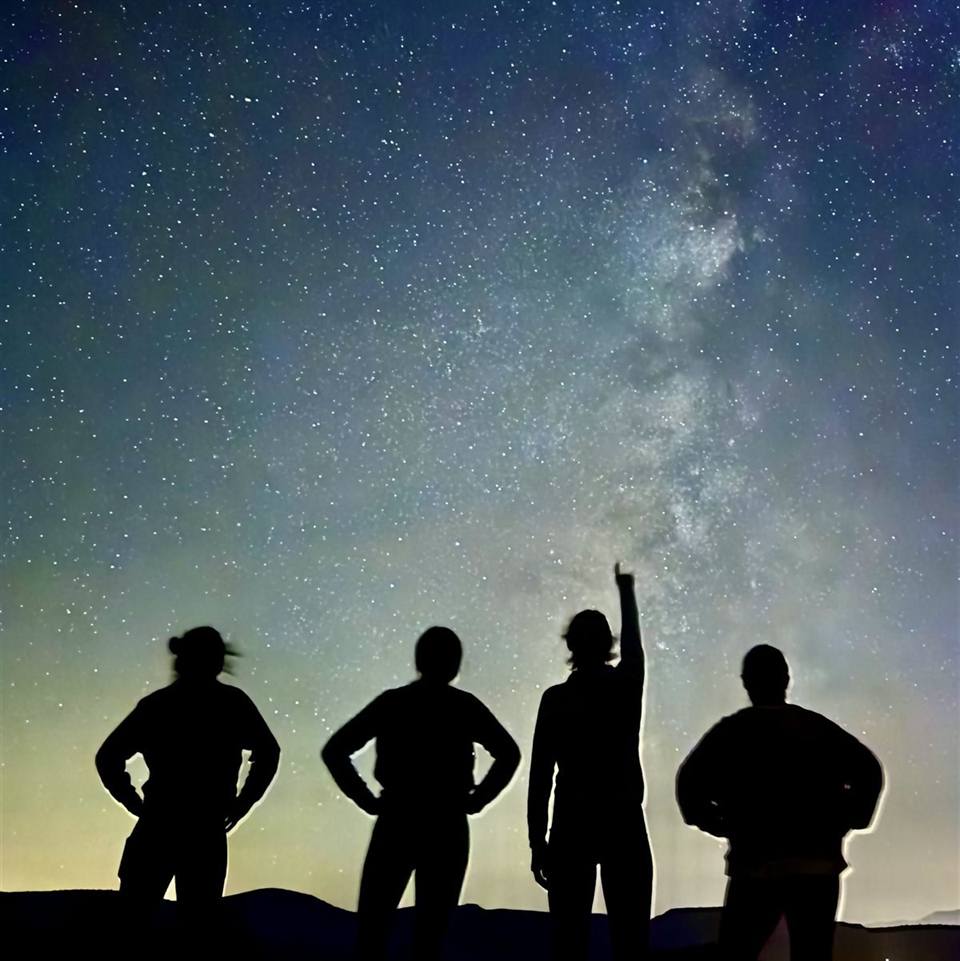 A group silhouetted against the Milky Way on a Sedona stargazing tour